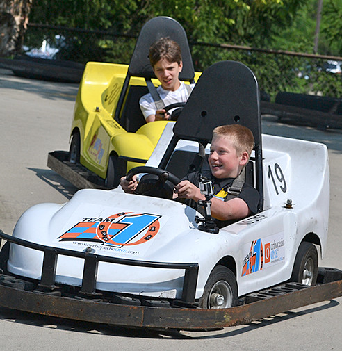 Two smiling young males driving go karts at PowerPlay at SportsOhio