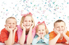 Happy kids with balloons smiling at the camera.